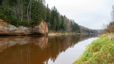 Nehir kenarındaki kumtaşı çıkıntılarının güzel manzarası, sonbahar manzarası, nehirdeki yansımalar, Gauja, Erglu kayalıkları, Letonya