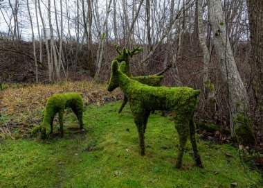 sonbahar manzarası yosundan yapılmış bahçe heykelleri, sonbaharda park, devrilmiş ağaç yaprakları, sonbahar