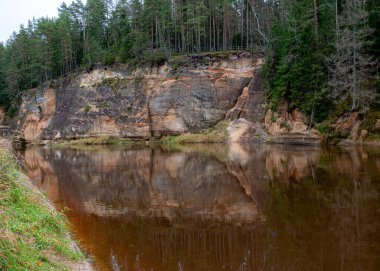 Nehir kenarındaki kumtaşı çıkıntılarının güzel manzarası, sonbahar manzarası, nehirdeki yansımalar, Gauja, Erglu kayalıkları, Letonya