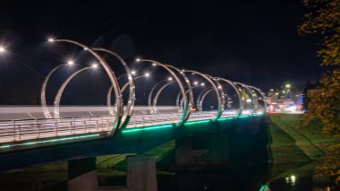 Renkli köprü ışıklandırmasıyla sonbahar manzarası, akşam alacakaranlığı, güzel, bulanık ışık nesneleri, Gauja, Valmiera, Letonya üzerindeki köprü