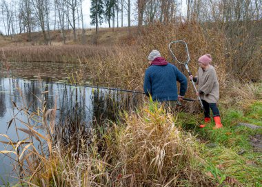 Balıkları kıyıya çekmeye çalışan iki balıkçı, balık kavramı, boş zaman eğlencesi, doğada eğlence, büyük hobi, sonbahar