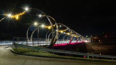 Şehir köprüsü şenlikli renklerle süslenmiş, parlak dekorasyonlar, gece manzarası, Valmiera, Letonya