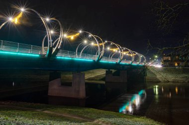 Şehir köprüsü şenlikli renklerle süslenmiş, parlak dekorasyonlar, gece manzarası, Valmiera, Letonya