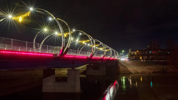 Şehir köprüsü şenlikli renklerle süslenmiş, parlak dekorasyonlar, gece manzarası, Valmiera, Letonya