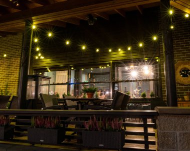 Noel havasında muhteşem dekore edilmiş şehir, çeşitli ışıklar ve dekorasyonlar, dekore edilmiş evler ve köknar ağaçları, gece manzarası, Valmiera, Letonya