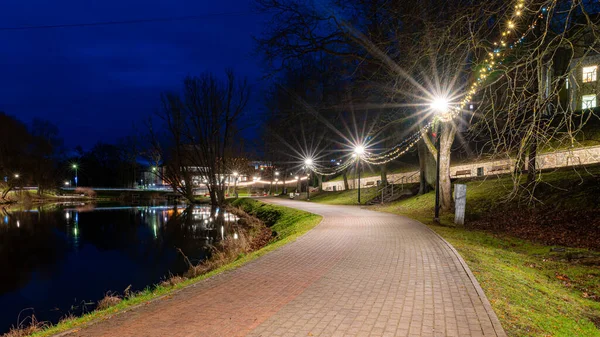 Noel havasında muhteşem dekore edilmiş şehir, çeşitli ışıklar ve dekorasyonlar, dekore edilmiş evler ve köknar ağaçları, gece manzarası, Valmiera, Letonya