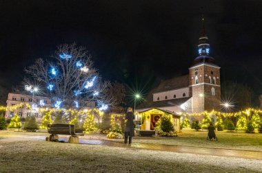 Noel havasında muhteşem dekore edilmiş şehir, çeşitli ışıklar ve dekorasyonlar, dekore edilmiş evler ve köknar ağaçları, gece manzarası, Valmiera, Letonya