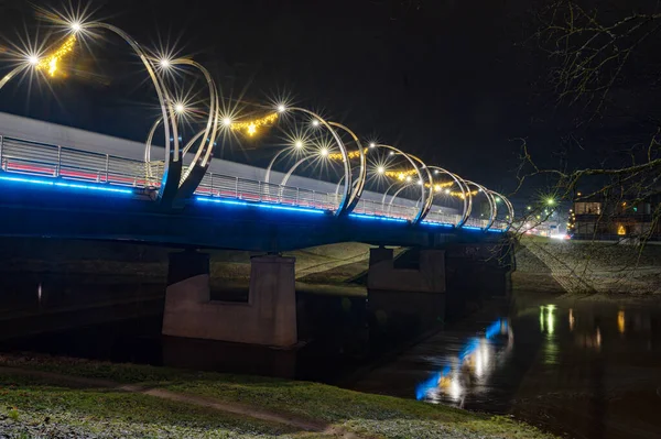 Şehir köprüsü şenlikli renklerle süslenmiş, parlak dekorasyonlar, gece manzarası, Valmiera, Letonya