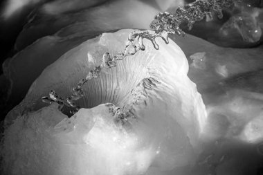 Donmuş bir buz kabına su sıçratan soyut fotoğrafçılık, siyah beyaz fotoğraf, kış günü.