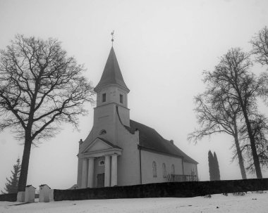 Bahar manzarası sabah sisli küçük bir kırsal kilise, nemli ve bulutlu hava, Rubene Kilisesi, Valmiera İlçesi, Letonya