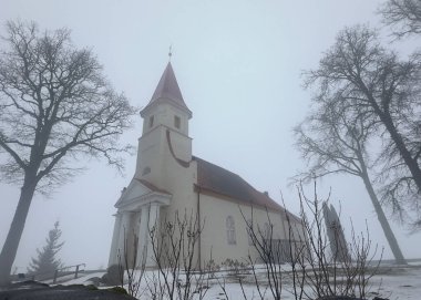 Bahar manzarası sabah sisli küçük bir kırsal kilise, nemli ve bulutlu hava, Rubene Kilisesi, Valmiera İlçesi, Letonya