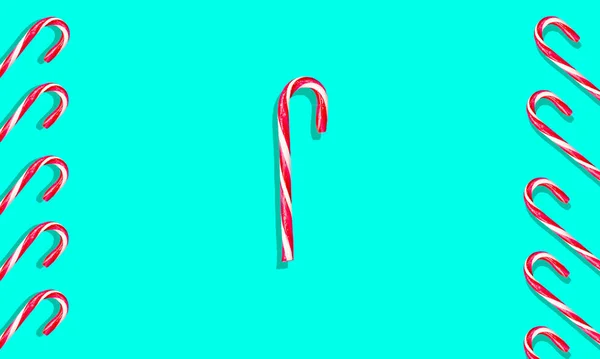 Buon Natale caramelle può in fila su sfondo blu. Schema di Natale. Posa piatta — Foto Stock