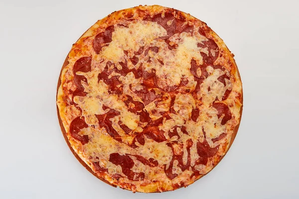 A whole round pizza with salami sausage and cheese on a white background.