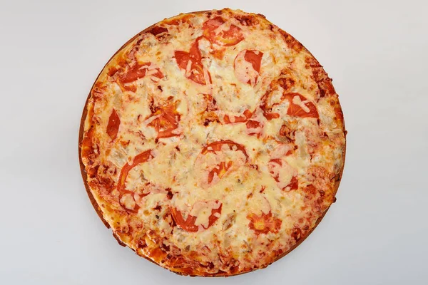 A whole round pizza with red tomatoes and cheese on a white background.