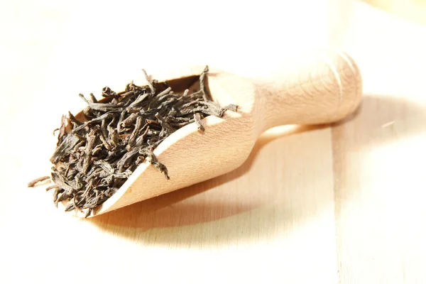 Czarna herbata liście na drewnianą łyżką — Zdjęcie stockowe
