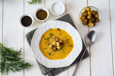 Lezzetli bezelye çorbası püresi, taze dereotu ve beyaz tabakta çıtır kraker. Üst görünüm