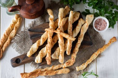 Lezzetli aperatif: Grissini sarımsaklı ve peynirli gri arka planda. Kahvaltı için ekmek çubukları