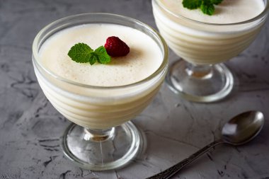 Lezzetli bir tatlı: böğürtlenli panna cotta ve güzel bir krema kasesinde nane.