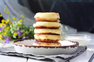 Tatlı kahvaltı: beyaz arka planda beyaz tabakta sıcak süzme peynirli krep..