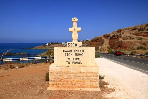 Pomos köyü, Paphos bölgesi, hoş geldin tabelasında Pomos Idol 'un temsilcisi. Yunanca sözcüklerin çevirisi: MÖ 3500, Pomos 'a Hoşgeldiniz