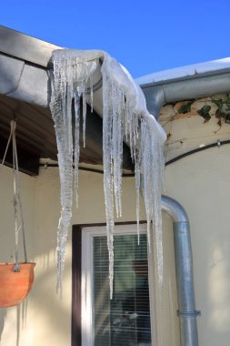 Evin çatısından sarkan buz saçakları