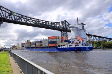 Almanya 'da Rendsburg - 22 Ağustos 2025: Kiel Kanalı' ndaki Rendsburg Yüksek Köprüsü 'nün altından geçen kargo gemisi