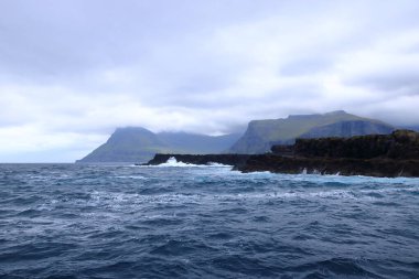 a dramatic view of Drangarnir gate in front of Tindholmur in Vagar island, Faroe Islands, Denmark, north atlantic ocean