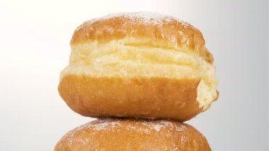 Beyaz arka planda haşlanmış konsantre süt ve çörek ısırığı izi var. Tatlı tatlı donut dönüyor..