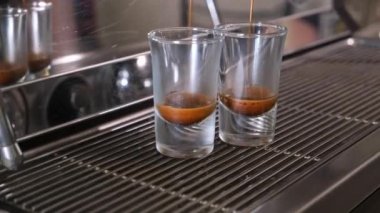 Kahve makinesiyle kahve makinesini şeffaf bardağa çevirme süreci, otomatik kahve makinesinden çıkan espresso kahvesi. Kahvaltıda içecek..