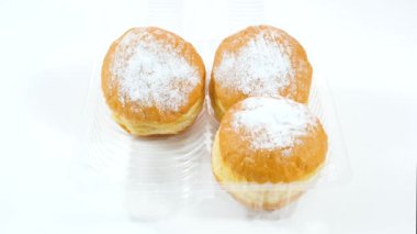 Kadın yavaşça plastik kutudan bir çörek çıkartıyor. Tatlı Pembe Kek. Kız plastik bir kutuyu mahvetti.