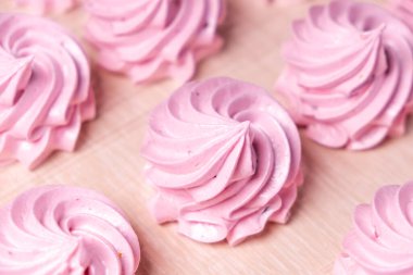 Parşömen arka planında el yapımı pembe şekerlemeler. Marshmallow, Meringue. Ev yapımı tatlı.