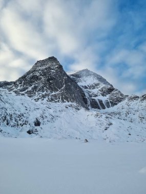Norveç, Lofoten Adaları 'nda kışın deniz ve dağlarla muhteşem kumlu Bunes plajı manzarası