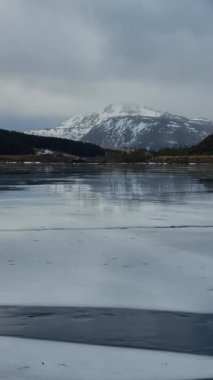 Buzdaki çatlakla kuzey manzarası. Donmuş bir gölde donmuş buz oluşumları inanılmaz bir dağla çevrili. Norveç 'in Lofoten adaları.     