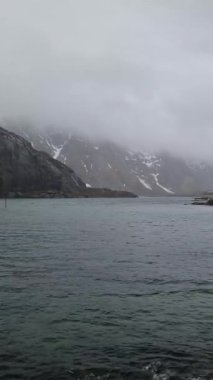 Lofoten Adaları 'nın güzel doğası. Norveç 'in dağları ve fiyortları. Kışın kıyı şeridi karla kaplanmış, fiyort manzarası, suda yansıma..