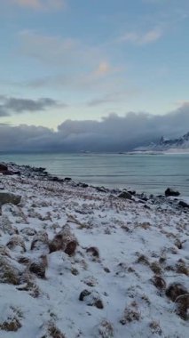 Lofoten Adaları 'nın güzel doğası. Norveç 'in dağları ve fiyortları. Kışın kıyı şeridi karla kaplanmış, fiyort manzarası, suda yansıma..