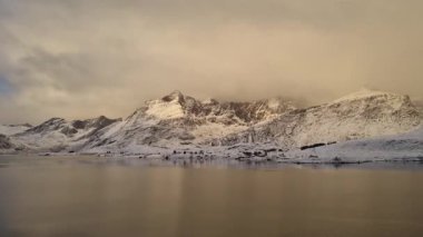 Norveç, Arktik, İskandinavya, Avrupa 'nın kışın Lofoten Gölü' ndeki güzel kar dağları ve altın gökyüzü manzarasını yansıtmaktadır.. 