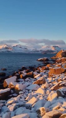 Norveç 'in gün batımında, Lofoten Adaları' nın güzel karlı dağları ve buzlu kıyıları.