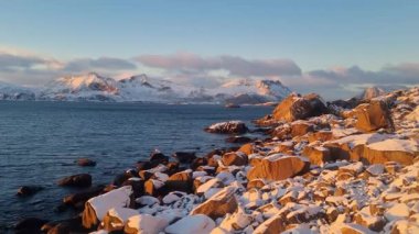 Norveç 'in gün batımında, Lofoten Adaları' nın güzel karlı dağları ve buzlu kıyıları.