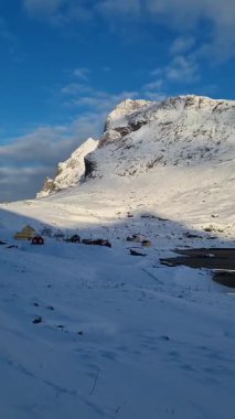 Terk edilmiş köy kırmızı ahşap evler ön ve dağlar ve okyanusun içinde belgili tanımlık geçmiş ile Lofoten Adaları Norveç'te Vindstad.