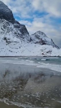 Norveç, Lofoten Adaları 'nda kışın deniz ve dağlarla muhteşem kumlu Bunes plajı manzarası