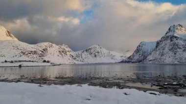 Norveç, Arktik, İskandinavya, Avrupa 'nın kışın Lofoten Gölü' ndeki güzel kar dağları ve mavi gökyüzü manzarası yansıyor.. 