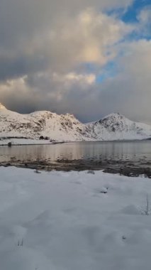 Norveç, Arktik, İskandinavya, Avrupa 'nın kışın Lofoten Gölü' ndeki güzel kar dağları ve mavi gökyüzü manzarası yansıyor.. 