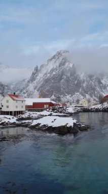 Svolvaer harbor panorama with boats, traditional and modern buildings, Snowy mountain on horizon. Lofoten islands, Norway.