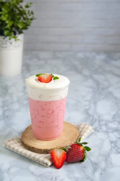 Strawberry milk shake on top cream cheese in glass plastic.