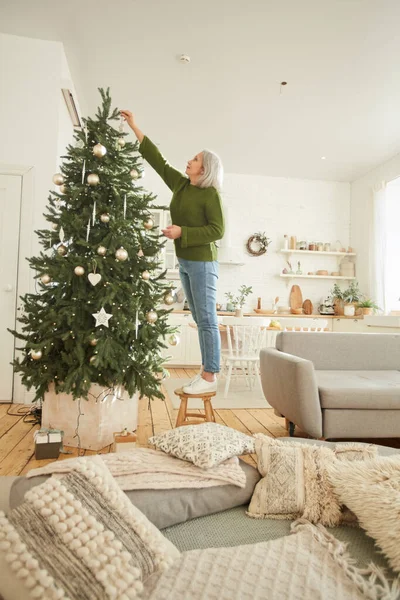 Mulher madura decorando árvore de Natal — Fotografia de Stock