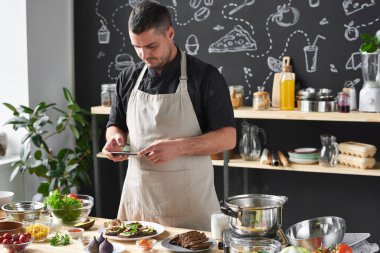 Şef yemeğin fotoğrafını çekiyor.
