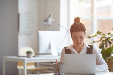 Ofiste dizüstü bilgisayar kullanan kadın