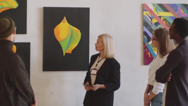 Professional Middle Aged Female Guide Telling Abstract Paintings Group Visitors — Stock Video