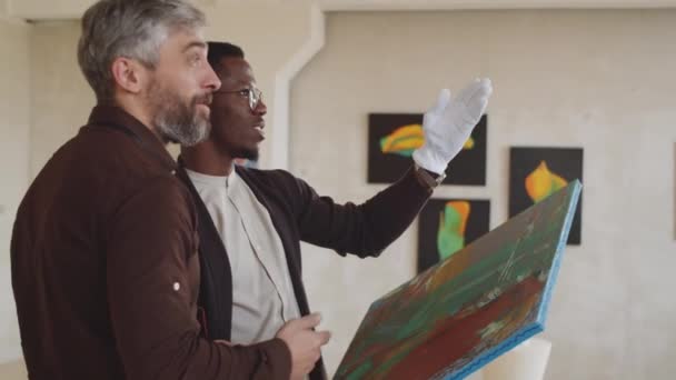 Deux Galeristes Multiethniques Masculins Discutent Endroit Accrocher Des Œuvres Tout — Video