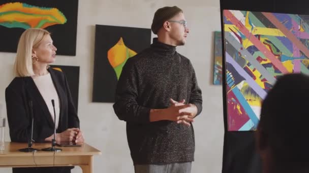 Ung Trendig Manlig Konstnär Talar Med Kvinnlig Auktionsförrättare Och Ger — Stockvideo